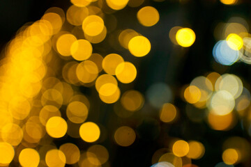Blurry holiday background with yellow bubbles bokeh.