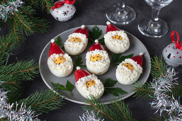 Stuffed eggs in the shape of Santa Claus on holiday background