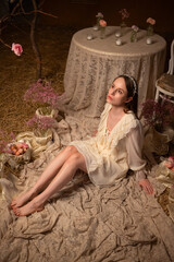 Woman in a vintage dress touching a rose in a romantic floral setting