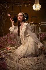 Woman in a vintage dress touching a rose in a romantic floral setting