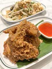 Crispy fried chicken with crunchy coating served with sweet chili dipping sauce and fresh salad