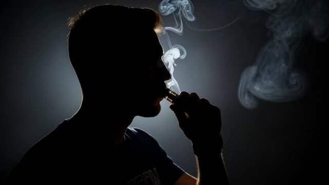 Silhouette of a man exhaling a large cloud of vapor from an electronic cigarette in a dark room.