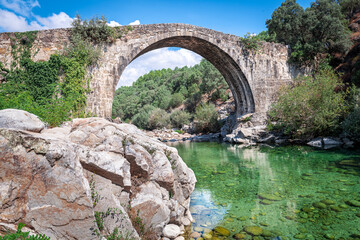 Imposing, high, historic, monumental Roman stone bridge structure.