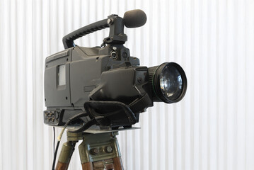 Old studio video camera on tripod, ion white background