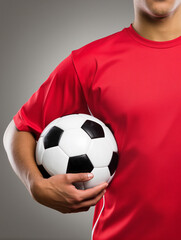 Soccer player holding ball in red jersey