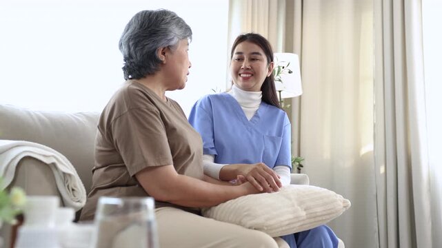Smiling nurse sharing joyful moment with elderly woman during home caregiving session, expressing empathy, laughter, and companionship that promote mental wellness, recovery, and positive relationship