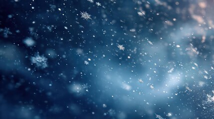 Abstract close up of falling snowflakes against a dark moody blue background with soft bokeh lights