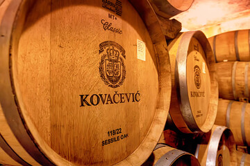 Obraz premium 31 August 2025, Irig, Serbia: Wooden barrels aging wine in a dim cellar, showing stacks of casks for fermentation in Kovacevic winery