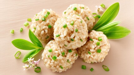 Group of savory rice balls garnished with finely chopped green herbs and presented with fresh leaves