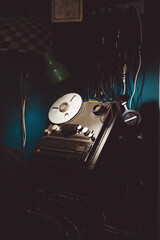 Professional reel to reel tape recorder machine in a dark music studio. Analog sound recording equipment with headphones and cables. Retro atmosphere for music creation and audio production background