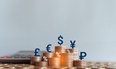 Stacked coins with wooden blocks with world currency symbols representing financial growth, exchange rates, investment, foreign exchange trading and international economy concept.