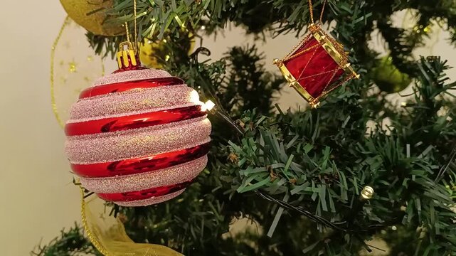 Close-up shot of perfect Christmas decoration with accessories and green New Year tree with red and white Christmas decoration and lights on its branches.