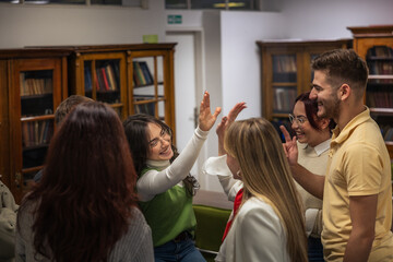 Happy students celebrating success with high five in classroom