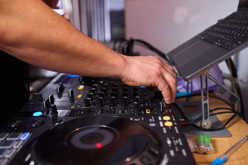 DJ setup overview, Energetic club DJ performing with digital controller in action, Content creator mixing music live using digital turntables under vibrant stage lights