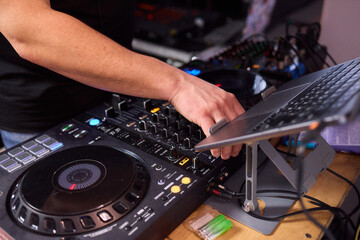 DJ setup overview, Energetic club DJ performing with digital controller in action, Content creator mixing music live using digital turntables under vibrant stage lights