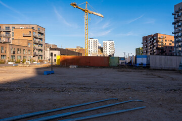 A steady construction scene features a crane towering above a developing site, surrounded by modern buildings, highlighting urban growth and industrial activity.