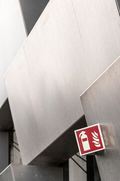 This image focuses on a fire safety sign amidst sleek industrial lines, emphasizing the importance of safety in modern engineering and architectural design.