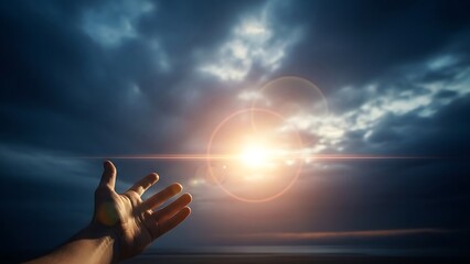 Hand reaching up towards bright sun flare and dramatic dark clouds in the sky
