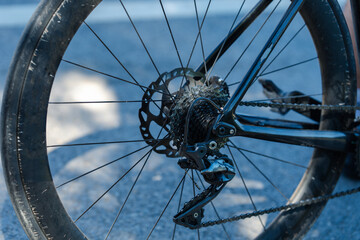 A close-up of a bicycle's rear wheel showcasing the brake disc, gears, and spokes against a blurred background.