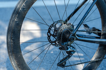 Close-up of a bicycle wheel showcasing the gear system, chain, and tire, highlighting the details of cycling mechanics and outdoor activity.