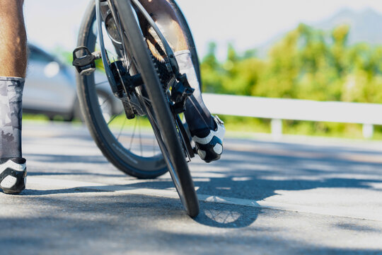 A cyclist experiences a flat tire on a sunny road, showcasing the struggle of cycling amidst beautiful surroundings. - Powered by Adobe