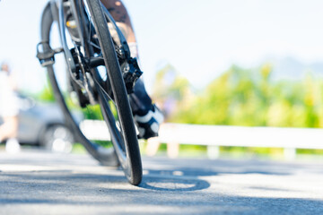 A close-up of a bicycle wheel on a smooth road, highlighting motion and speed in a vibrant outdoor setting.