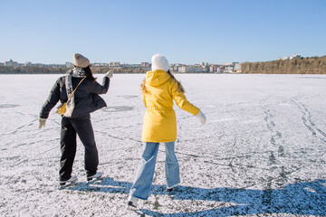 Young women enjoying winter ice skating outdoor activity