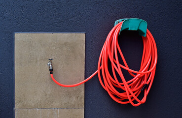 Orange garden hose on the wall, Ribeirao Preto, Brazil