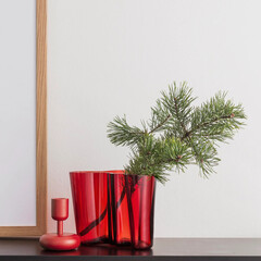 pine branch in a red designer glass is a beautiful minimalistic Christmas composition in the interior