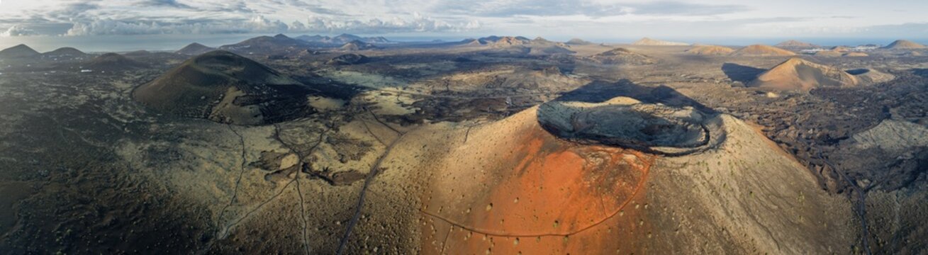 Caldera Colorada volcano and Monta&ntilde;a Negra, picturesque volcanic landscape with volcanic craters and lava fields in morning light, Parque Natural de Los Volcanes, aerial view, Lanzarote, Canary Islands, Spain