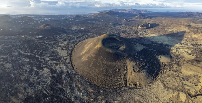 Monta&ntilde;a Negra volcano, picturesque volcanic landscape with volcanic craters and lava fields in morning light, Parque Natural de Los Volcanes, aerial view, Lanzarote, Canary Islands, Spain