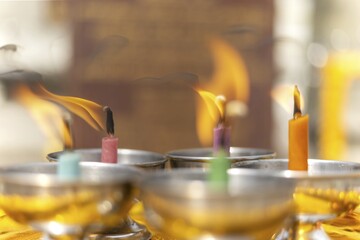 Oil lamps lit by believers as a symbol of the light of wisdom (the light dispels darkness and ignorance) in front of a Buddha statue, Wat Yannawa in the Sathon district, Bangkok, Thailand