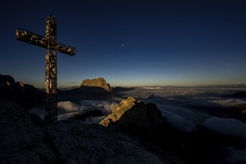 Summit cross of the large Cirrspitze with Dolomite peaks in the background, Corvara, Dolomites, Italy