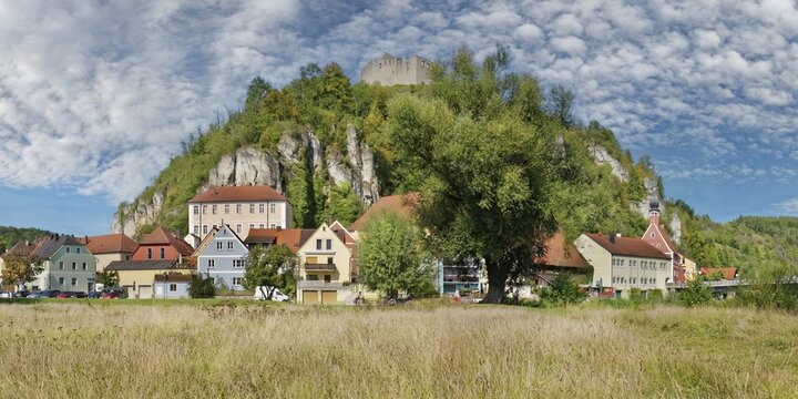 View of the small town of Kallm&uuml;nz below the castle ruins looming on a limestone cliff and lively nature and imposing sky, Kallm&uuml;nz, Upper Palatinate, Bavaria, Germany