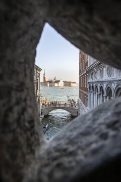 View from the Bridge of Sighs through a small hatch, Ponte della Paglia bridge and San Giorgio Maggiore church, prison, Doge's Palace, Venice, Veneto, Italy