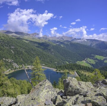 Path through a rocky cirque with a view of the Wei&szlig;brunnsee lake, Ulten, South Tyrol, Italy