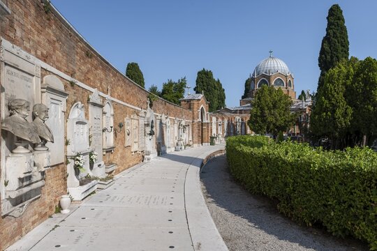 Graves on a wall, behind the dome of St Christopher's Church, San Michele cemetery island, Venice, Italy