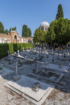 Graves, dome of St Christopher's Church at the back, San Michele cemetery island, Venice, Italy