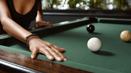 Female player with elegant bracelet reaching for cue ball on green felt pool table, surrounded by colorful billiard balls, showcasing focus and skill in a recreational setting