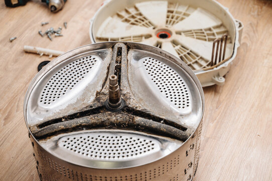 Washing machine drum prepared for repair, showing appliance maintenance and service work.