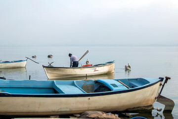 Naklejka premium fishing man and fishing boats on the lake shore, golyaka bursa 