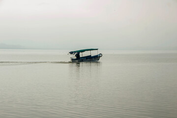 boat floating in lake water in foggy weather, Uluabat lake Bursa 