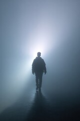 Fototapeta premium Mysterious silhouette of male walking in foggy light