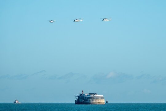 Portsmouth England - November 30 2025: A wildcat and two merlin helicopters flypast over Spitbank Fort in the Solent to welcome home the Carrier Strike Group 25 CSG 25 deployment Operation Highmast
