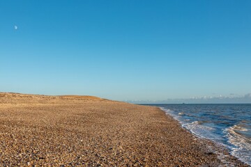 deserted beach at Browndown Hampshire England with blue sky in the background