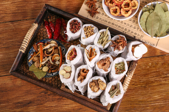 Traditional Asian Spices and Herbs Collection in Wooden Basket with Star Anise Bay Leaves and Cooking Seasonings