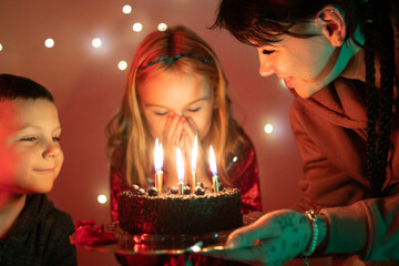 Little girl blowing out birthday candles making a wish