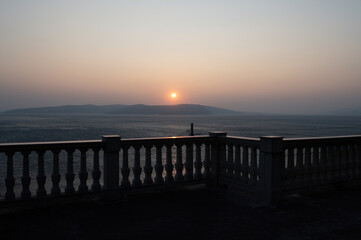 Obraz premium View from a terrace with column railing to the sea at sunset