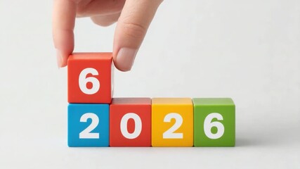 Hand Placing Number Six on Colorful Blocks Representing Year 2026 in a Bright and Minimalistic Setting 4k video footage