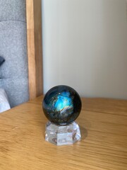 Blue labradorite crystal sphere on clear stand